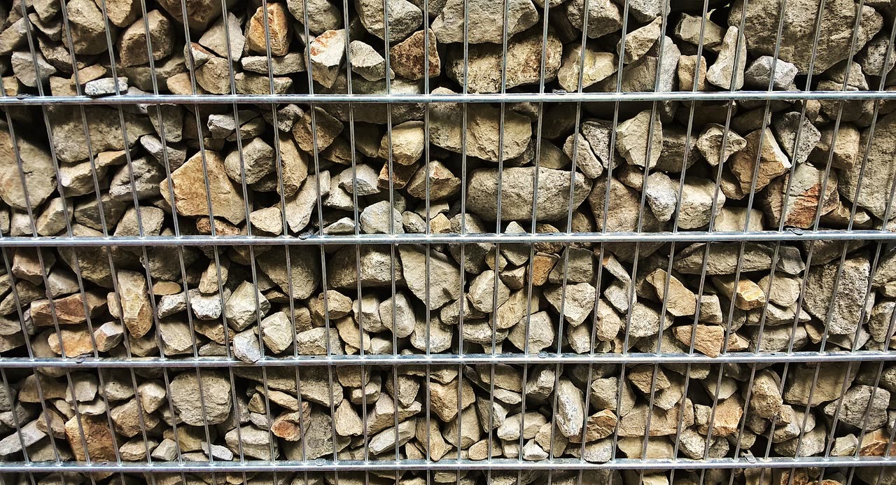 Pilhas de pedra britada classificadas por granulometria na saída da planta