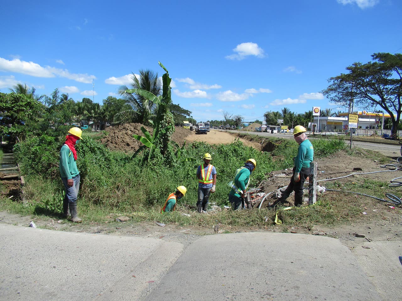 Equipe de trabalhadores com capacetes em canteiro de obras de infraestrutura viária